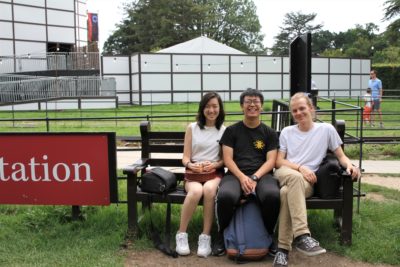 Exeter College Summer Programme Students sitting on a bench, smiling.